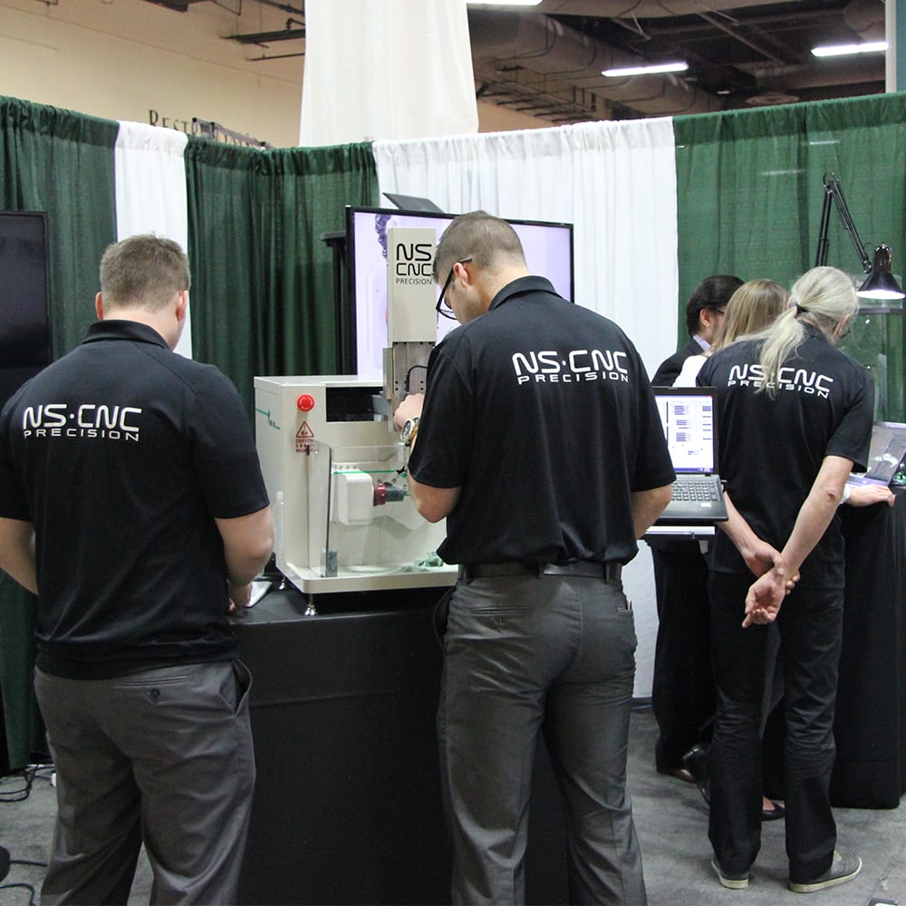 The NS CNC team demonstrating a machine on their trade show stand