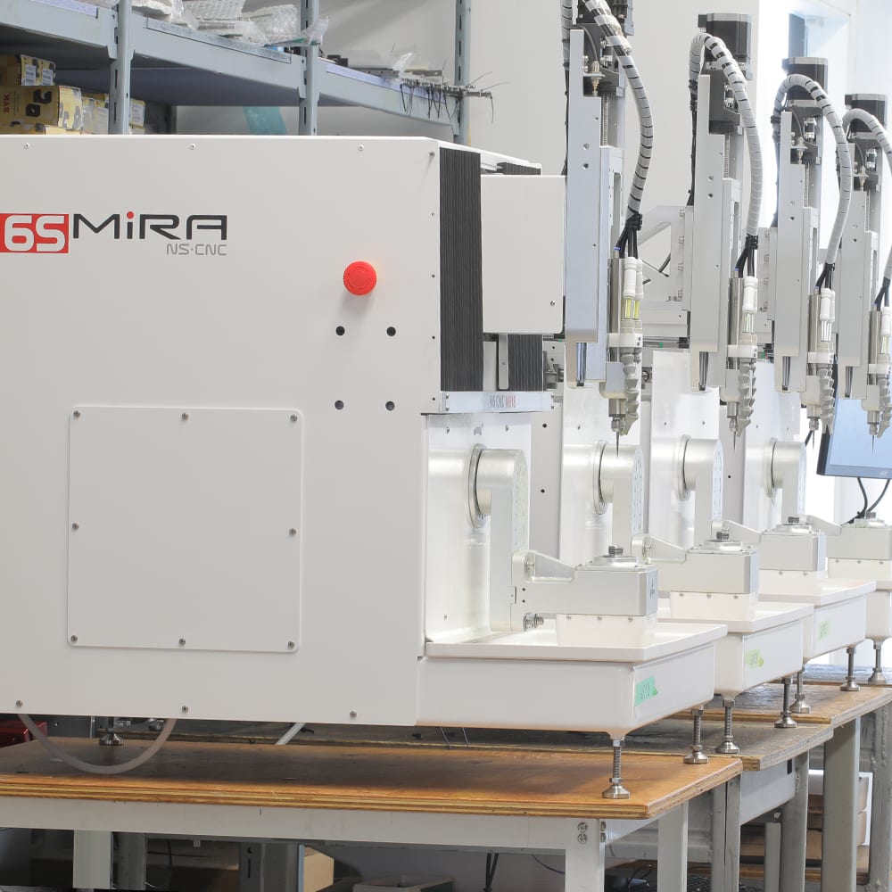A row of Mira 6S machines on the assembly benches in the NS CNC shop