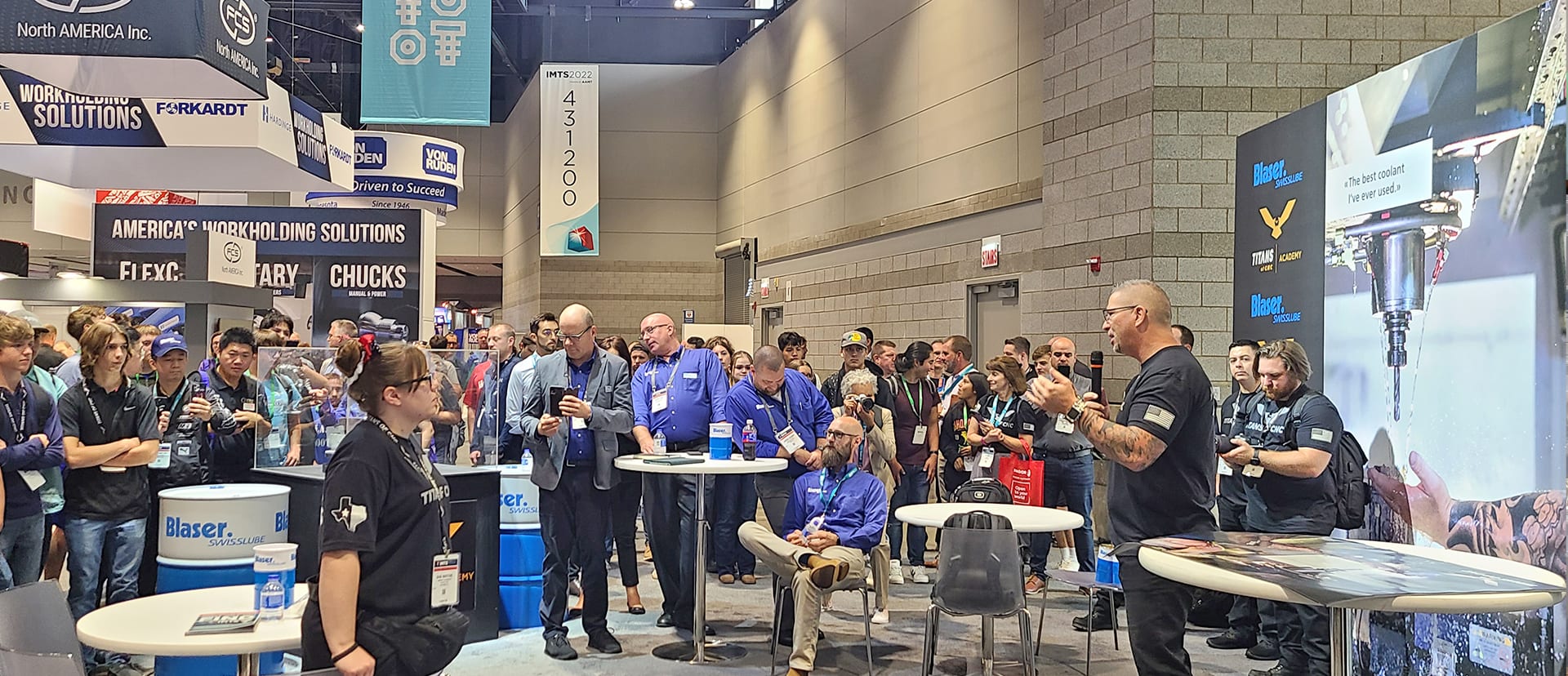A crowd gathered around a live presentation on the IMTS 2022 show floor