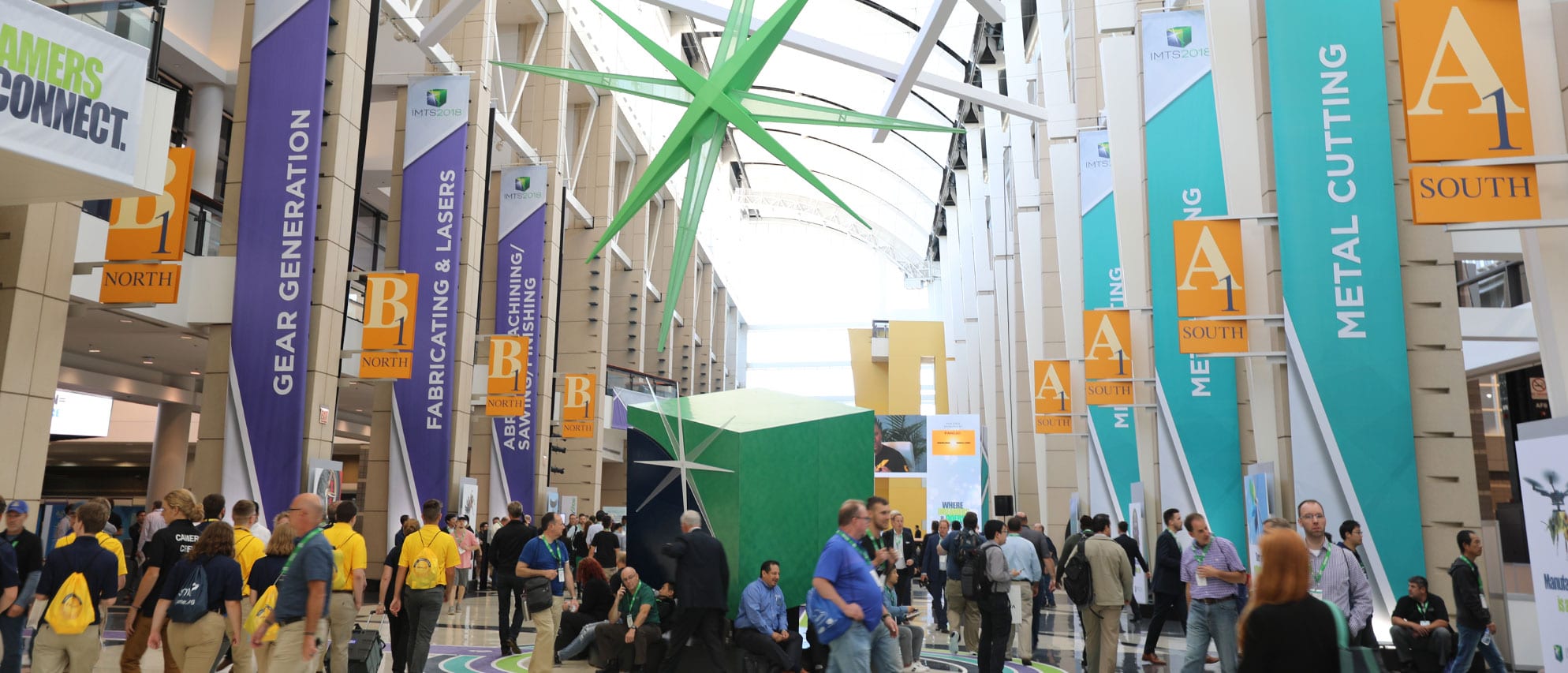 The IMTS 2018 concourse at McCormick Place, Chicago, crowded with visitors under hanging show banners