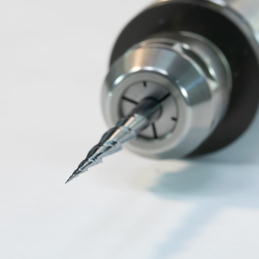 The Mira-Bit clamped in the spindle collet, tip toward the camera