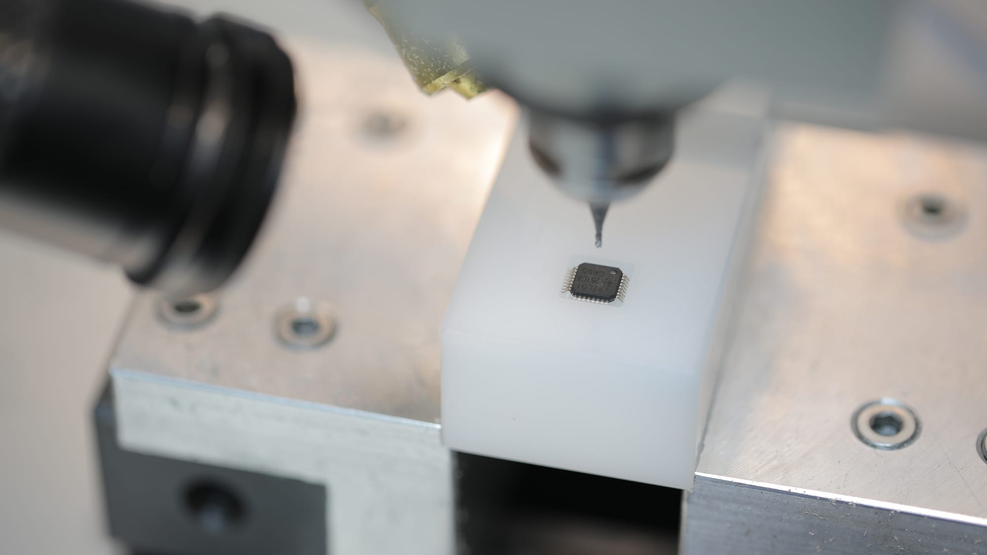Microchip held in a custom micro-vacuum fixture below the spindle