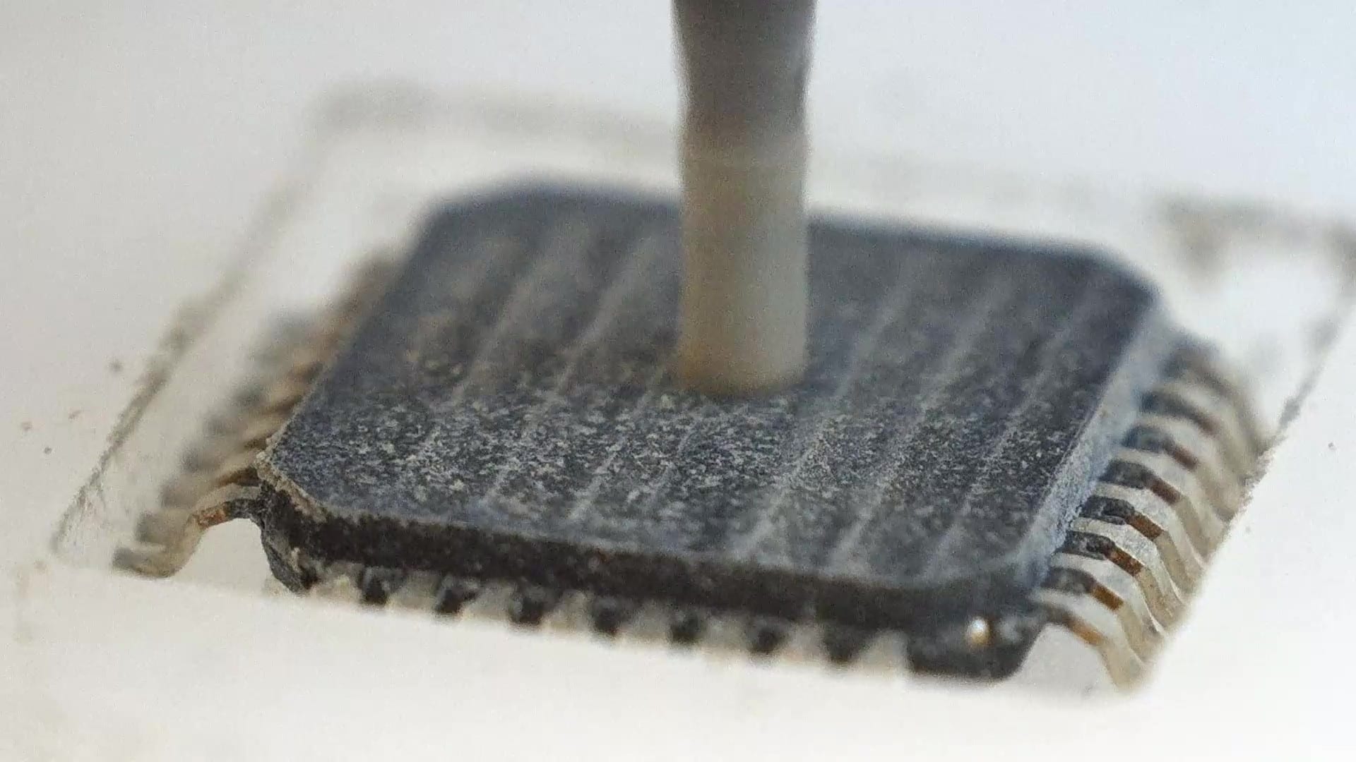 Close view of a cutting tool removing material layer by layer from the surface of a microchip