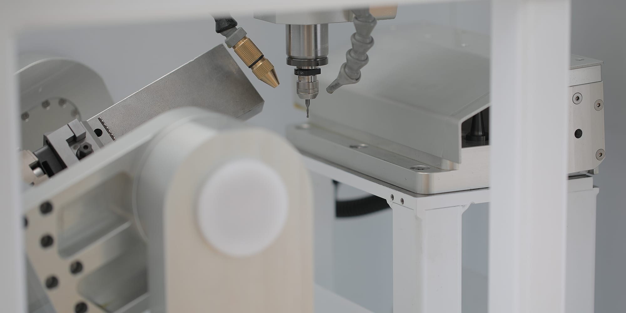 The spindle with a tool in the collet, directly above the closed magazine cover