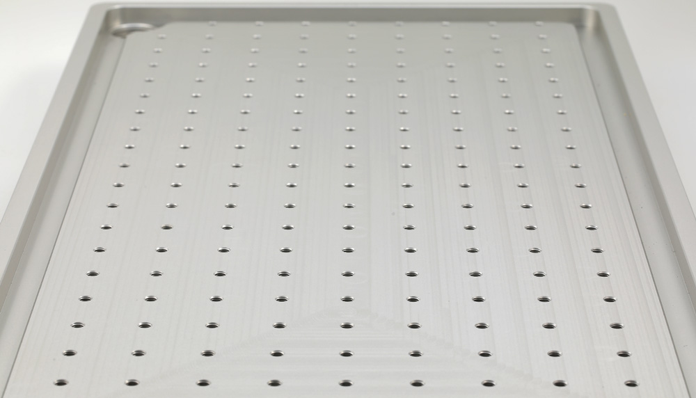 The Elara 2 X table from above: a grid of threaded mounting holes at 25 millimeter intervals, the raised perimeter rim, and a drain hole in the corner